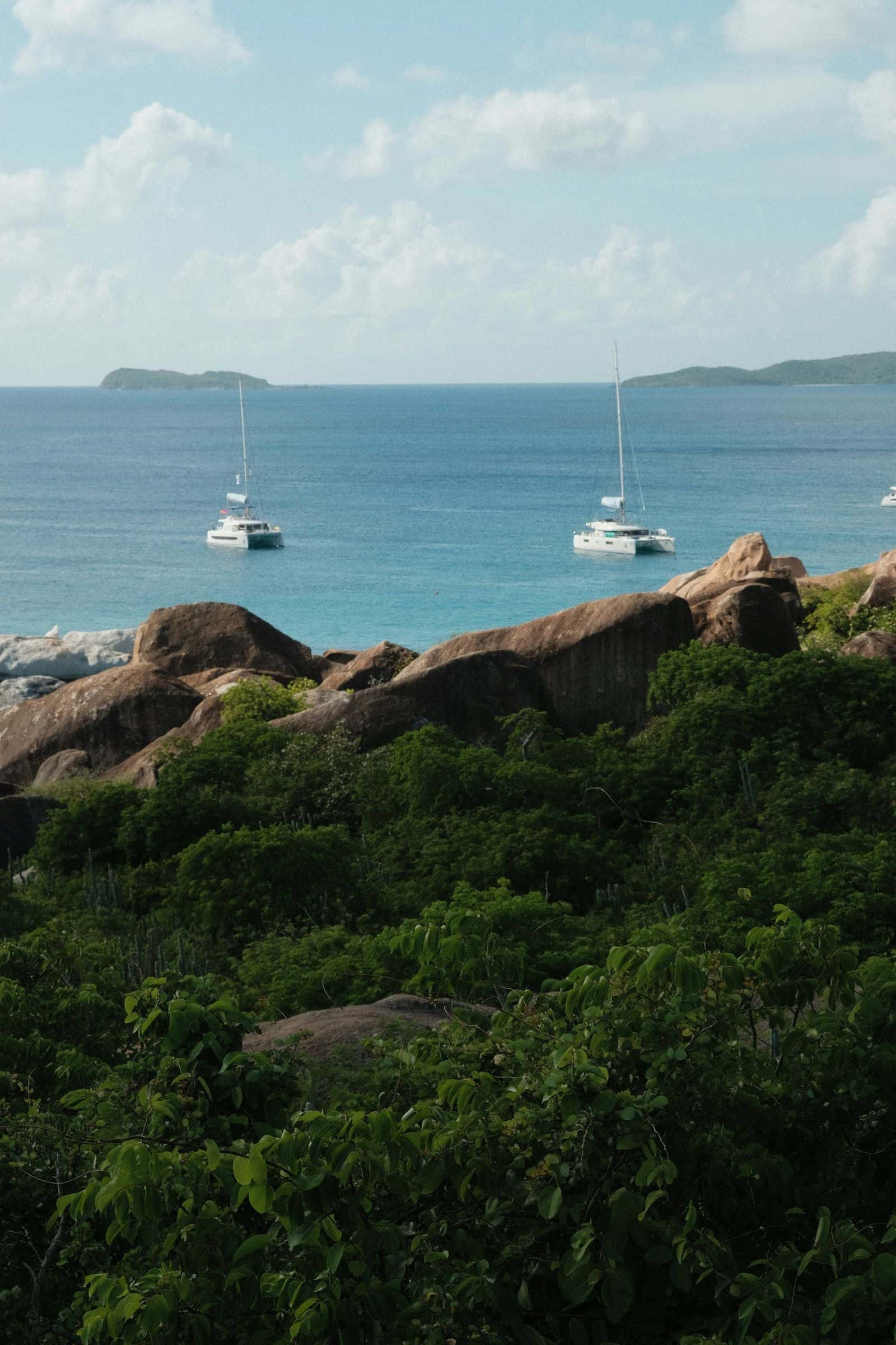 Granite boulders and anchored catamarans off the coast of Virgin Gorda, seen from the hillside