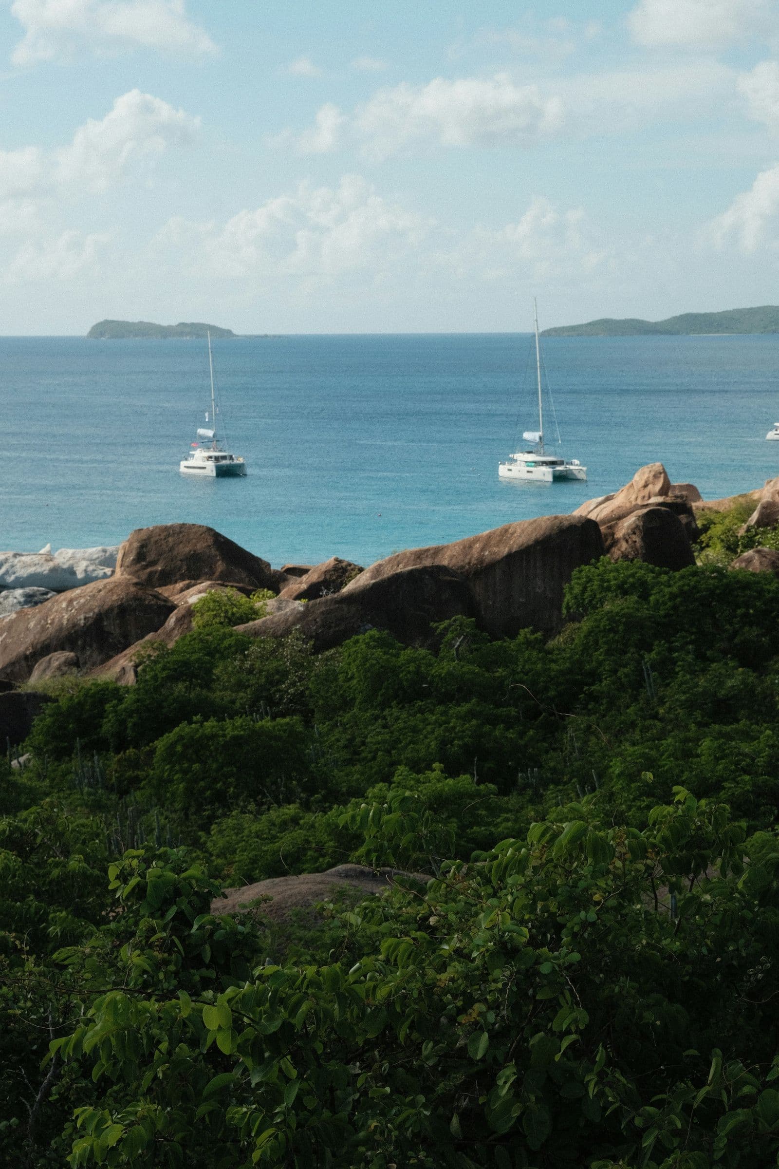 Granite boulders and anchored catamarans off the coast of Virgin Gorda, seen from the hillside
