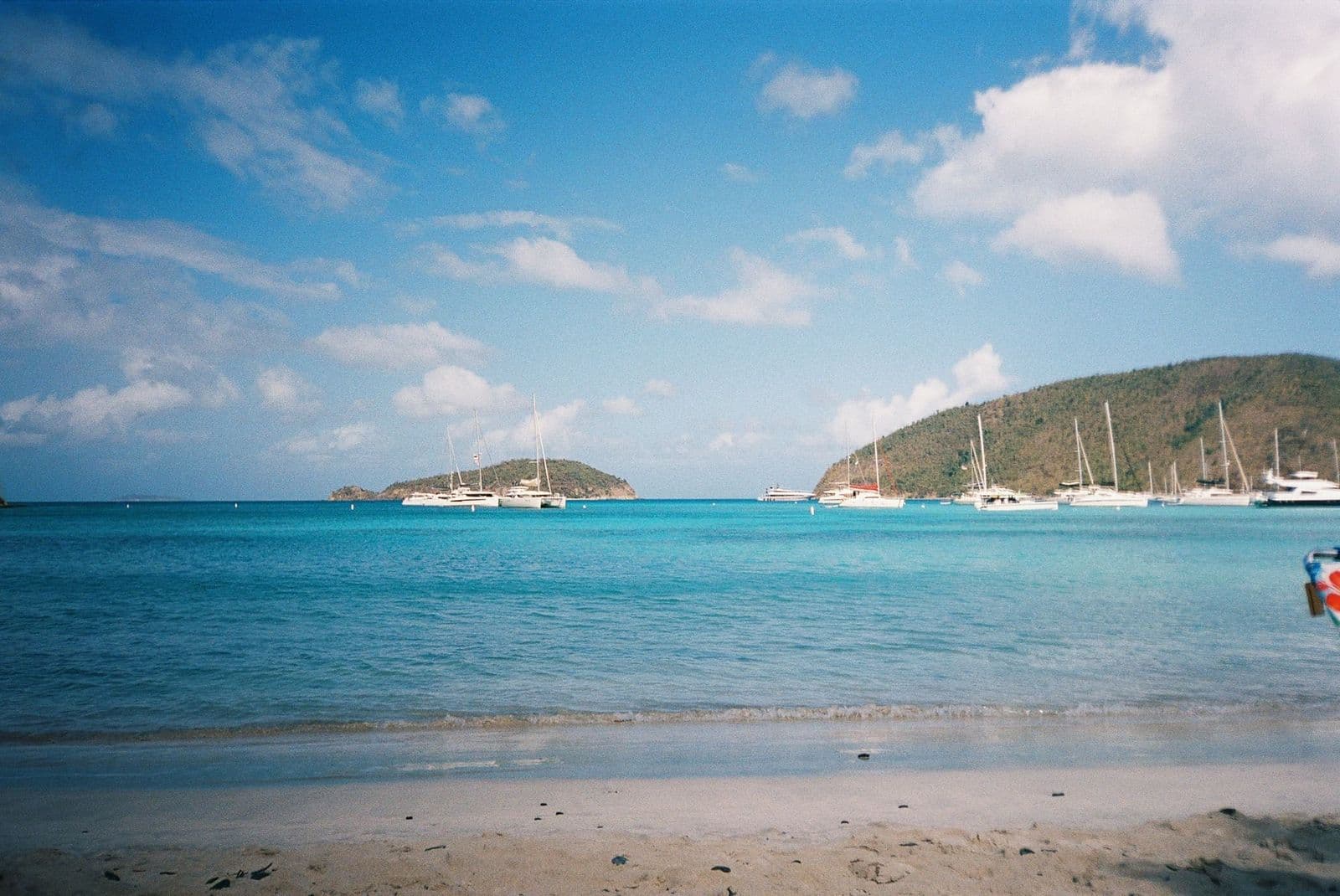 Sailboats off a beach with other British Virgin Islands behind