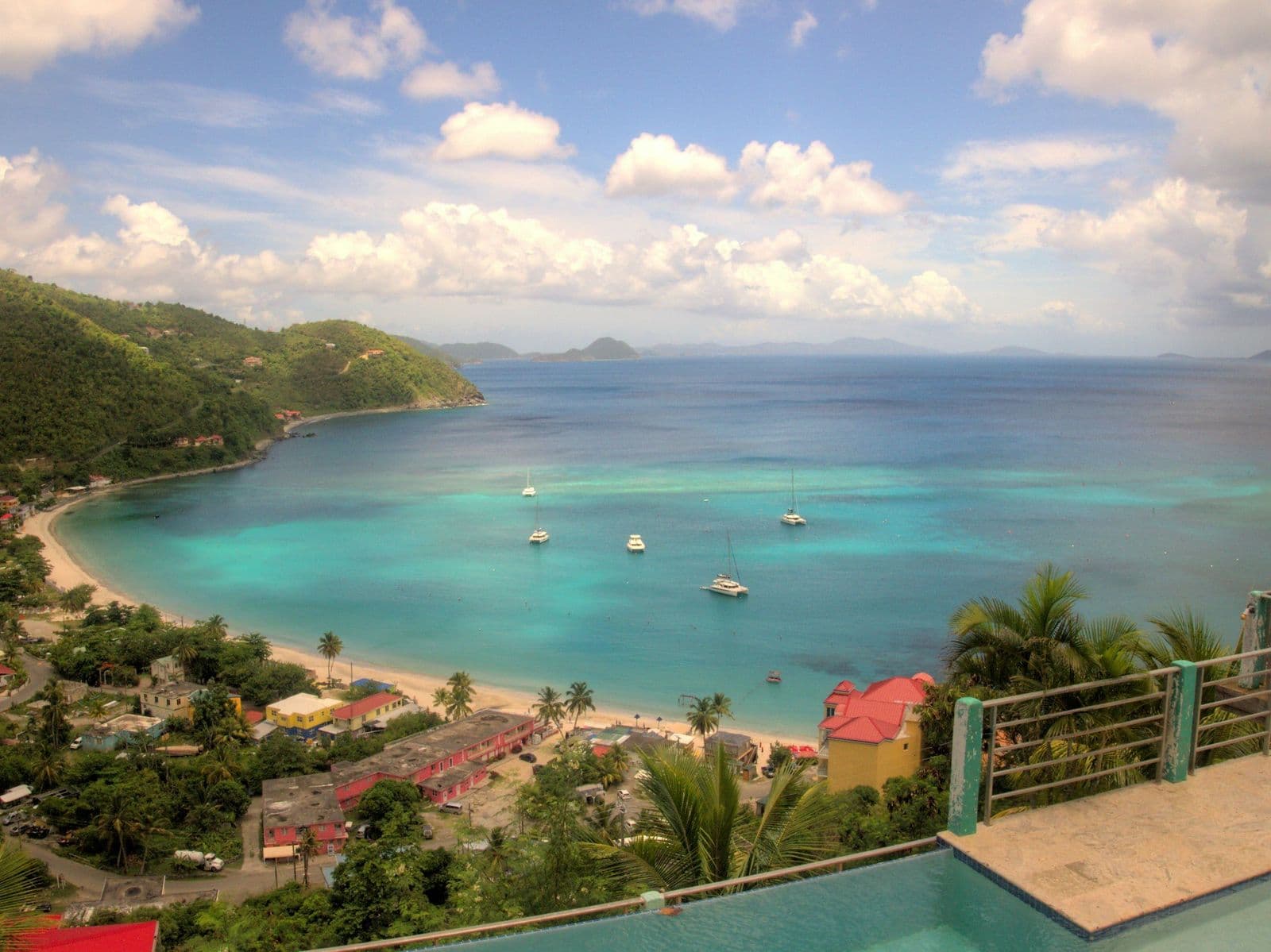 Cane Garden Bay, Tortola, from the hillside, the beach curving round turquoise water, boats moored