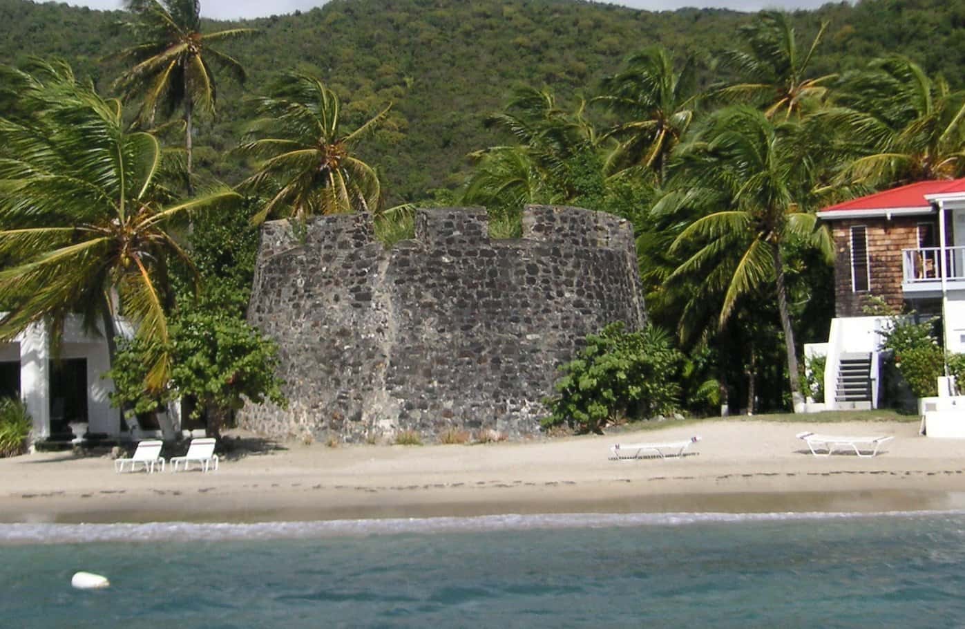 Fort Recovery's round stone tower on the beach at Tortola's west end, under palms