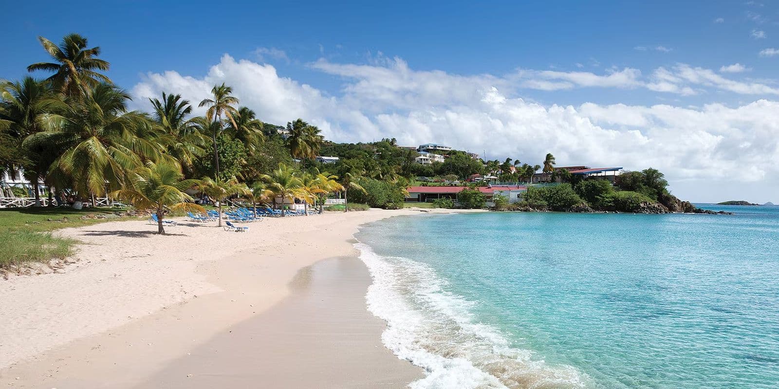 Limetree Beach, St. Thomas: a crescent of pale sand, small surf and palms, with a low resort on the point.