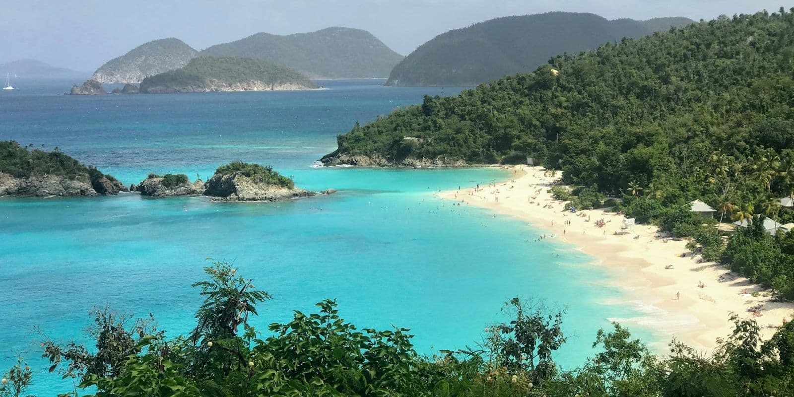 Trunk Bay, St. John, from the overlook: the white beach, Trunk Cay and turquoise water, with cays on the horizon.